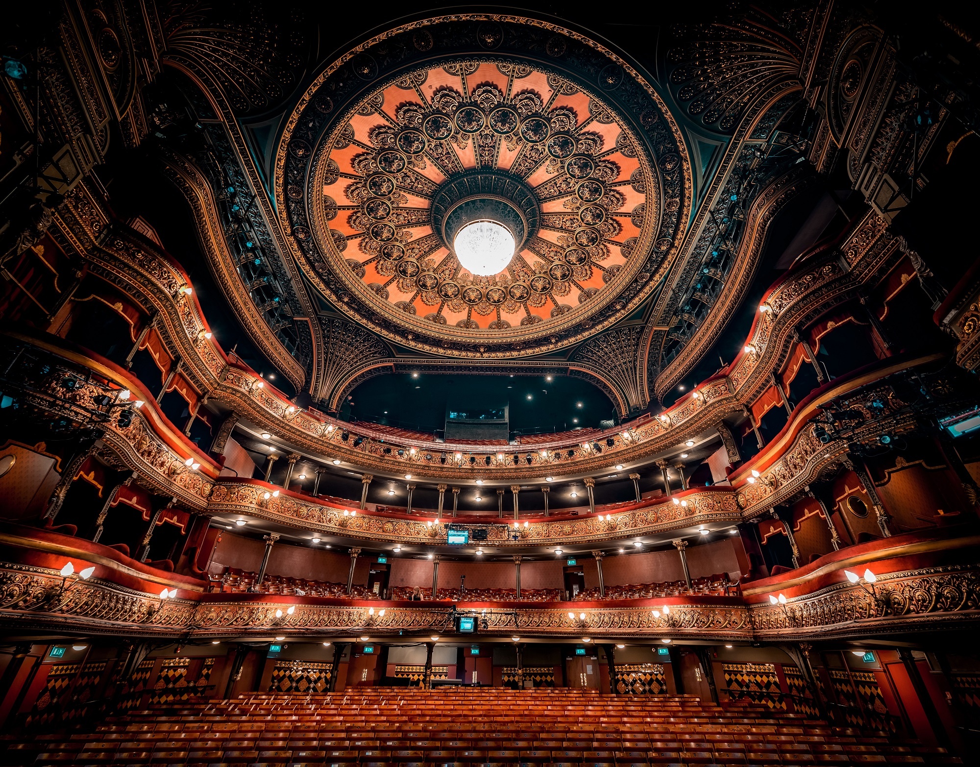 a theatre setting with three floors of seating and a large decorated ceiling rose