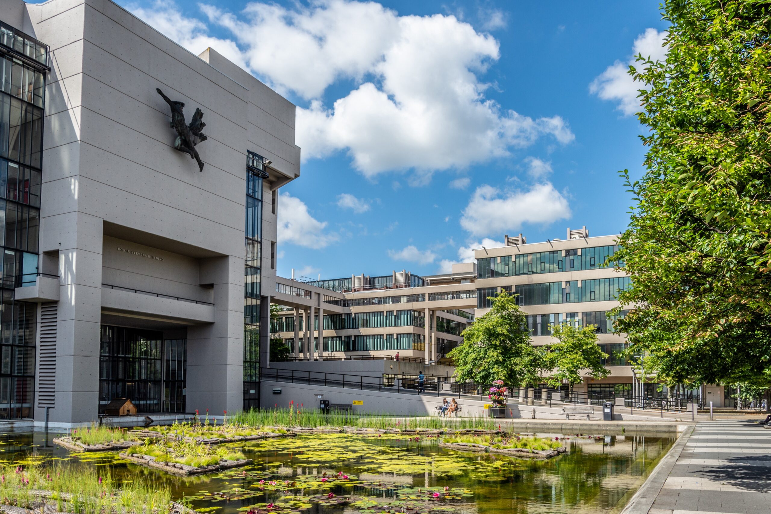 Blue sky and greenery in front of Roger Stevens Building at the University of Leeds