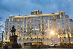 The Queens Hotel at dusk outside with statues in front