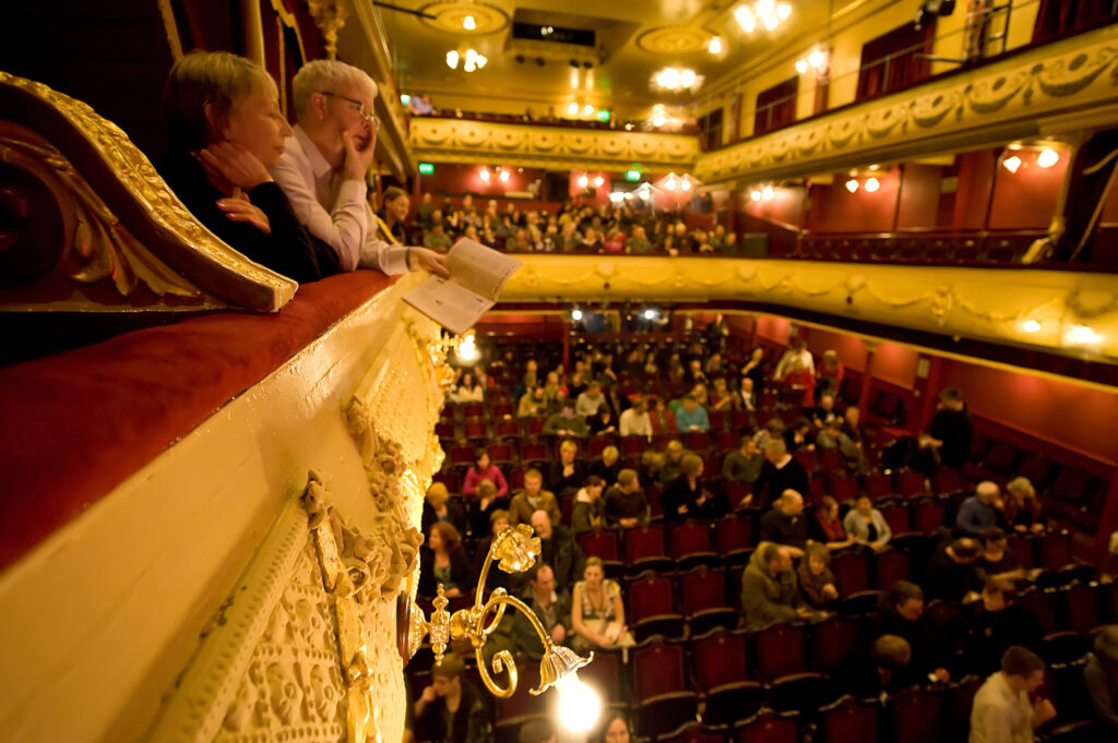 people watching from over a balcony at theatre show