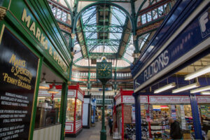 a large market hall with glass roof and a clock tower in the middle