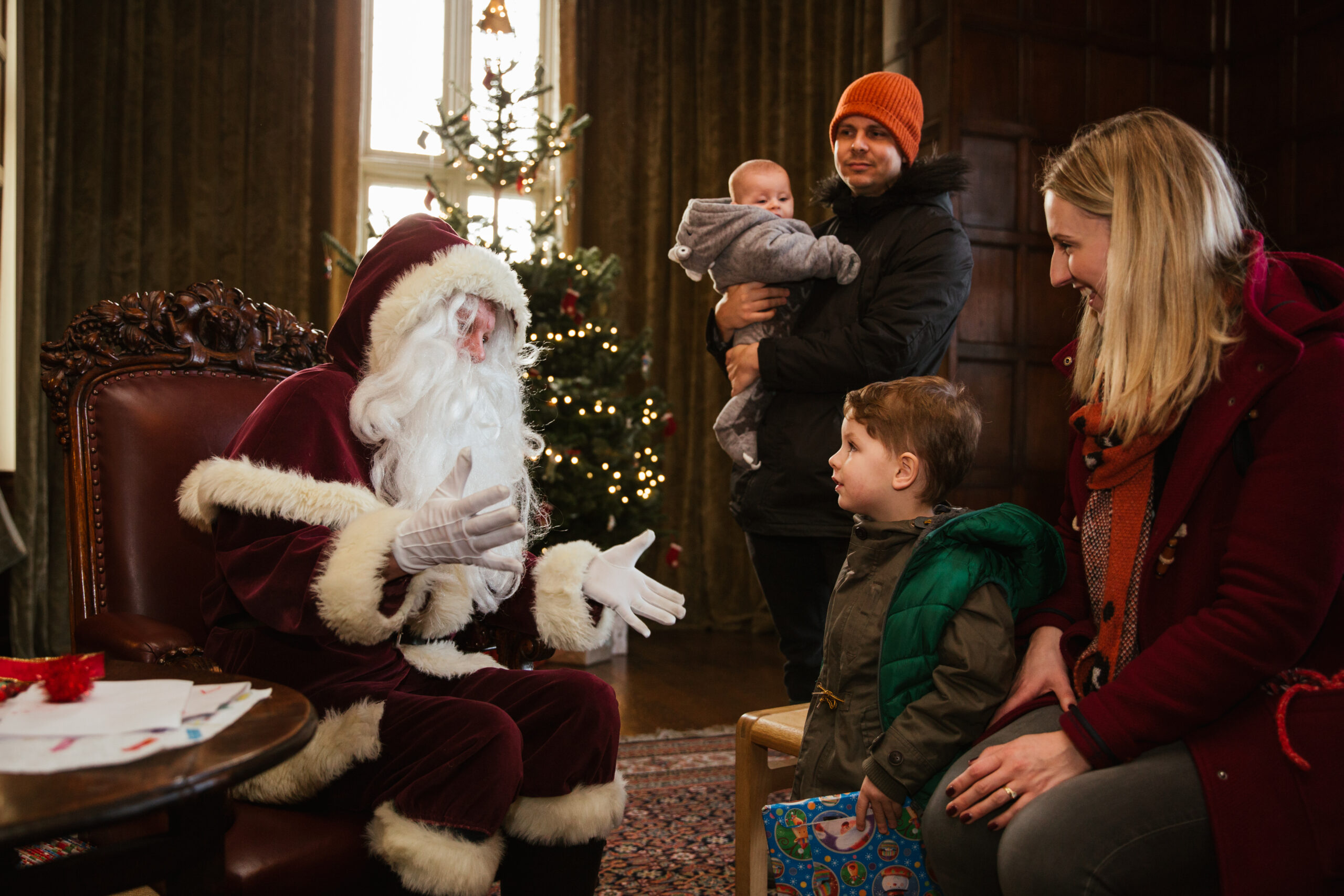 A young family talk to Father Christmas at Temple Newsam