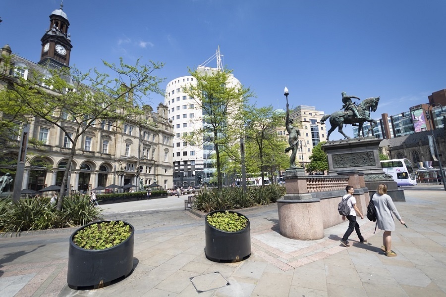 Photograph of City Square in Leeds showing blue skies and people walking