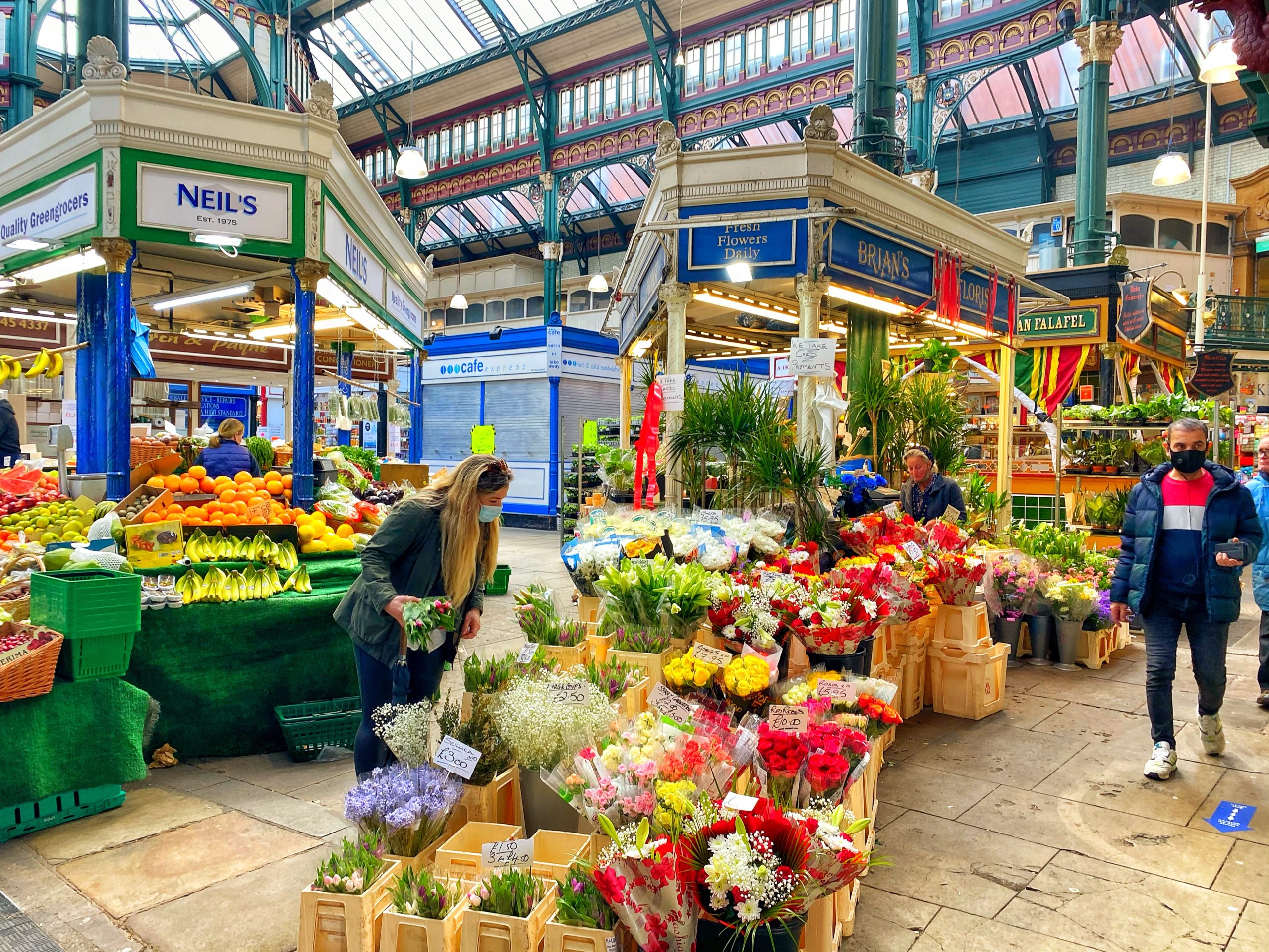 Flower stall at the Kirkgate market with people browsing around