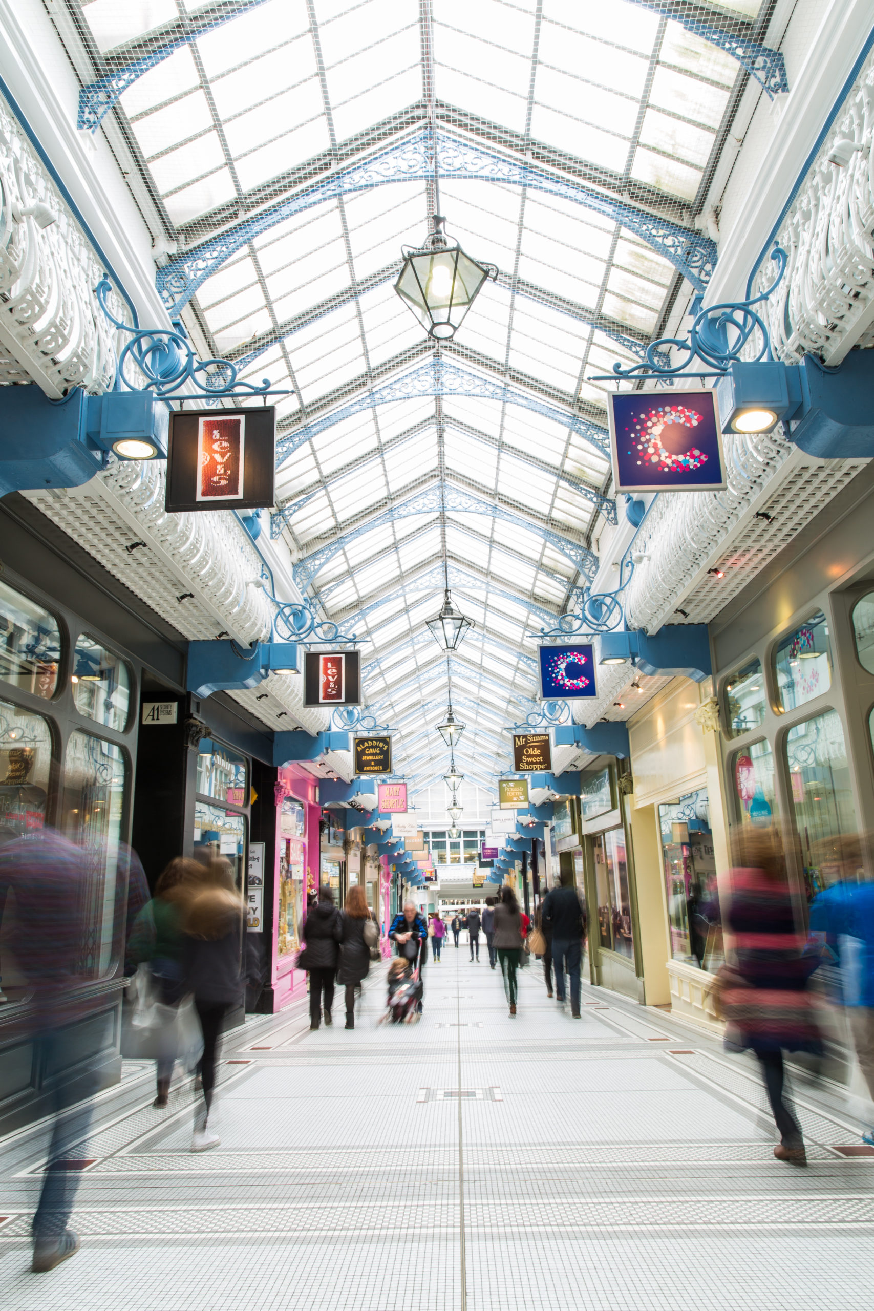 Picture of the Queens Arcade Leeds with people walking past shops