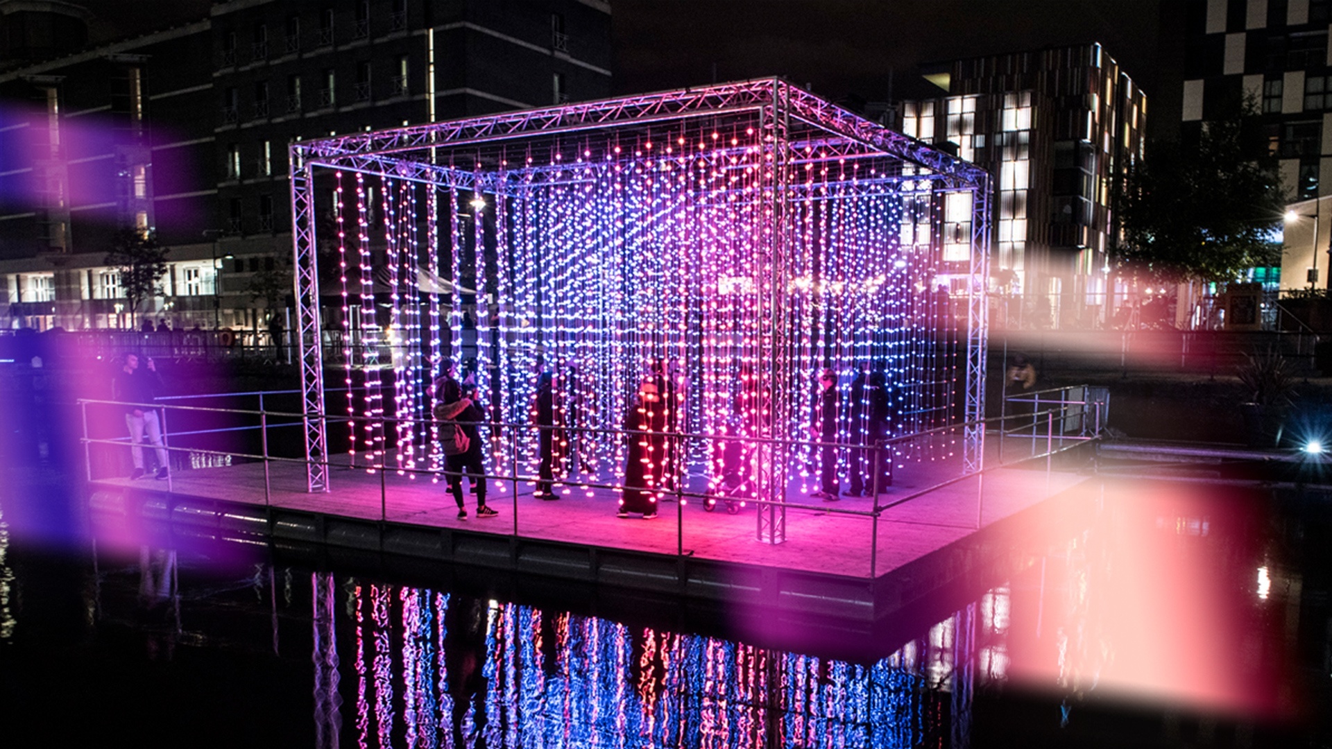 A lit up cube floats on the water at Leeds Dock as part of Light Night installation.