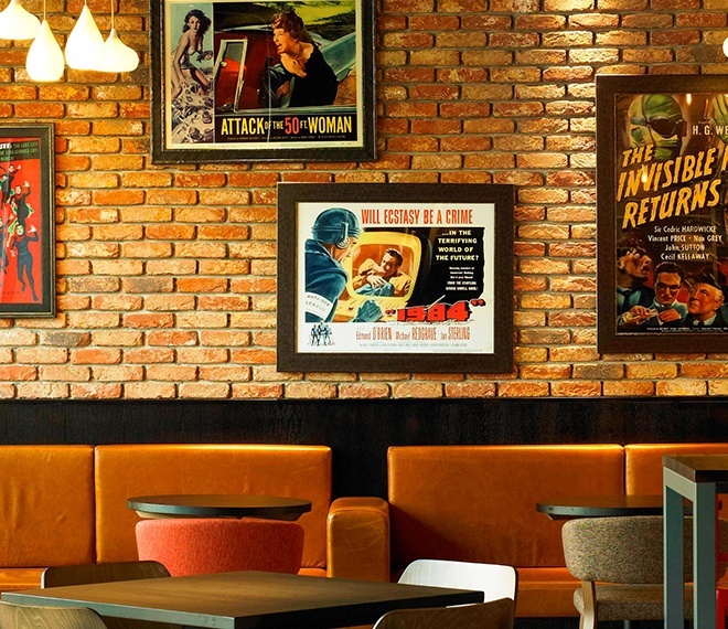 Picture of a wall with painting and posters inside a restaurant