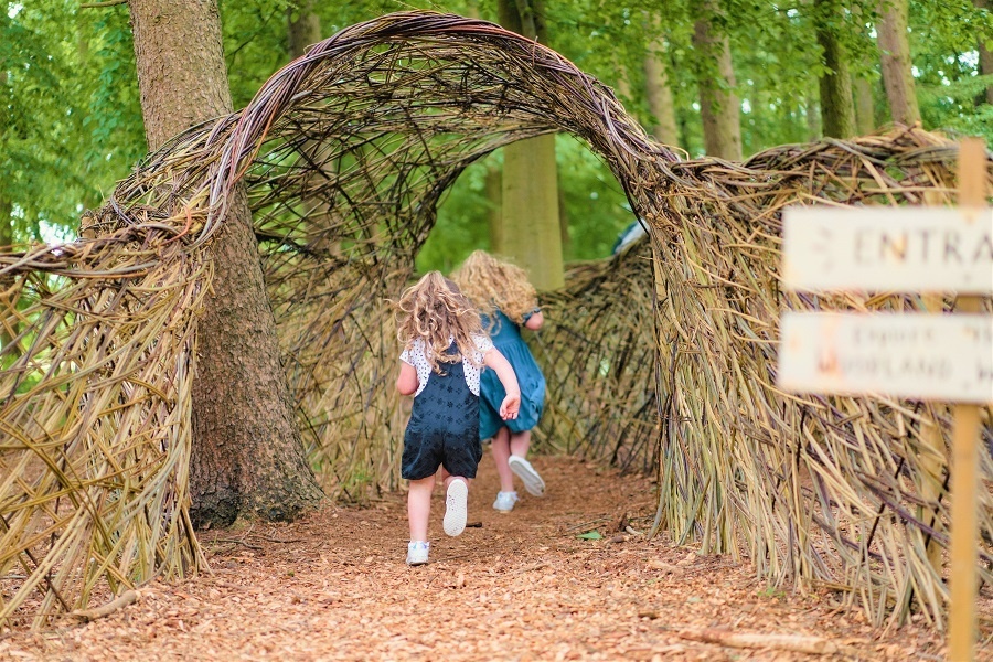 two children run through a woven structure