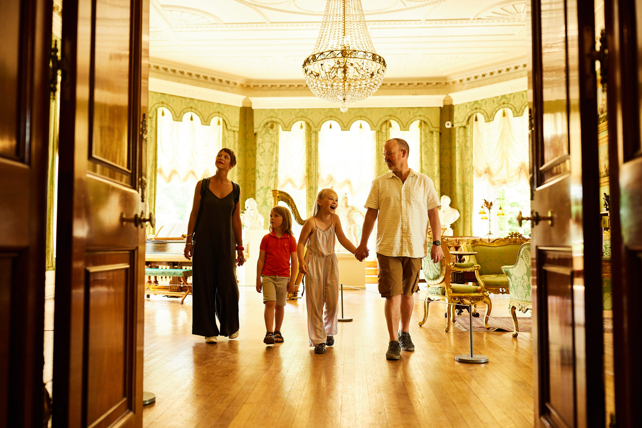 Family hold hands and wander the interior of Lotherton in awe