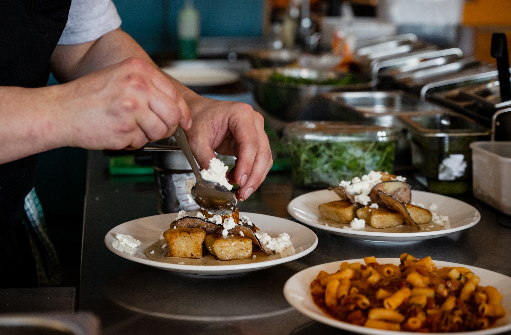 A chef plating up meals at Sarto restaurant