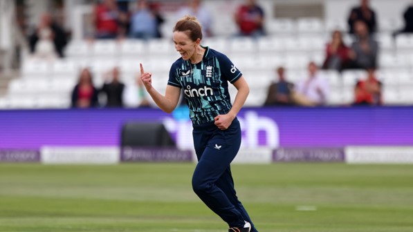 Photograph of Kate Cross, cricket player on the pitch celebrating.