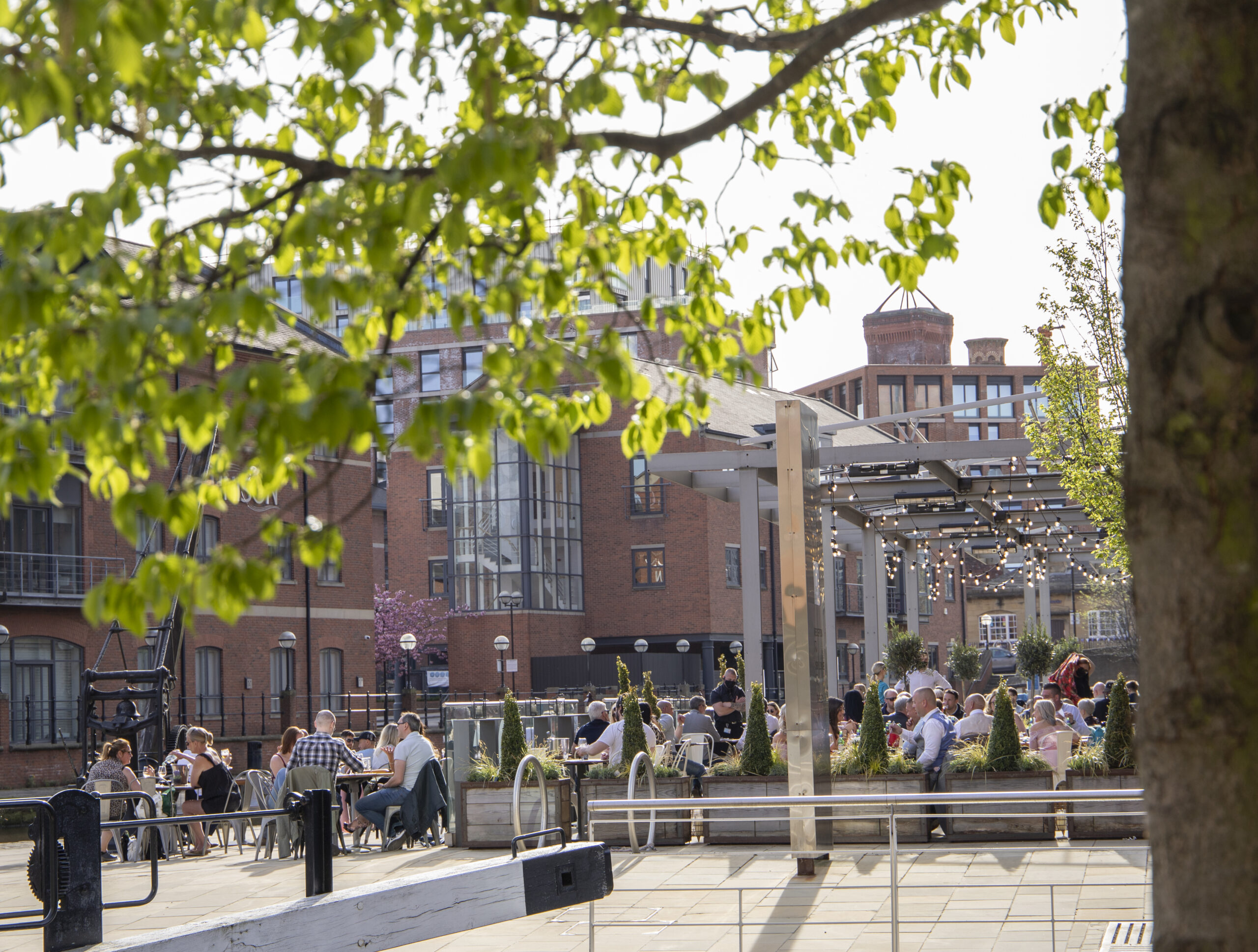 Picture of Leeds dock in Granary Wharf with people enjoying the sunshine on a terrace