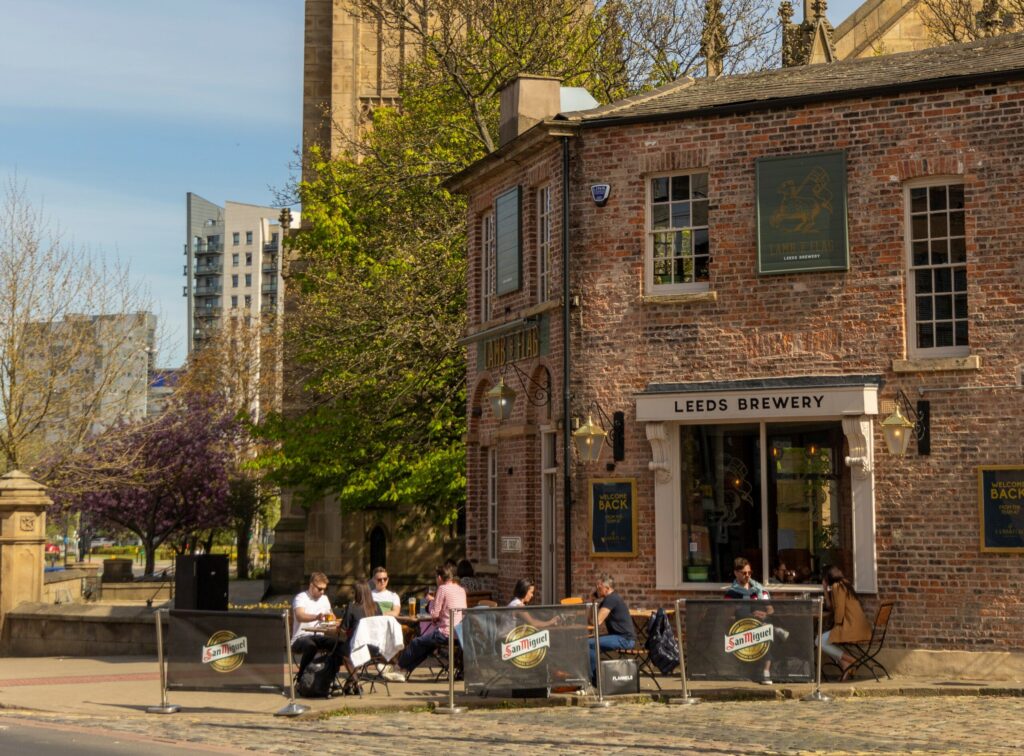People sitting outside the Lamb and Flag pub on a sunny day,