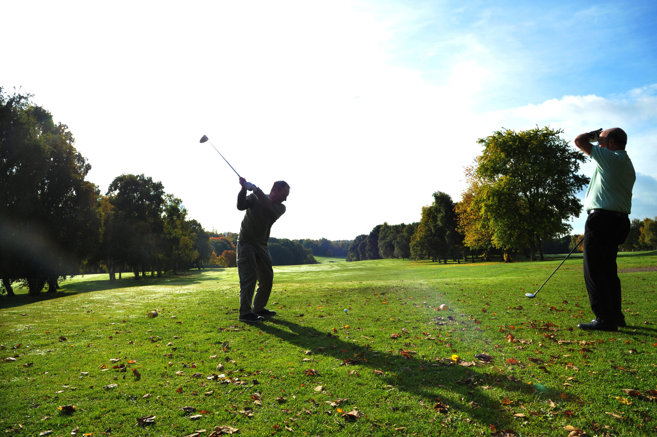 Two men playing golf on a sunny day at Temple Newsam Golf Club