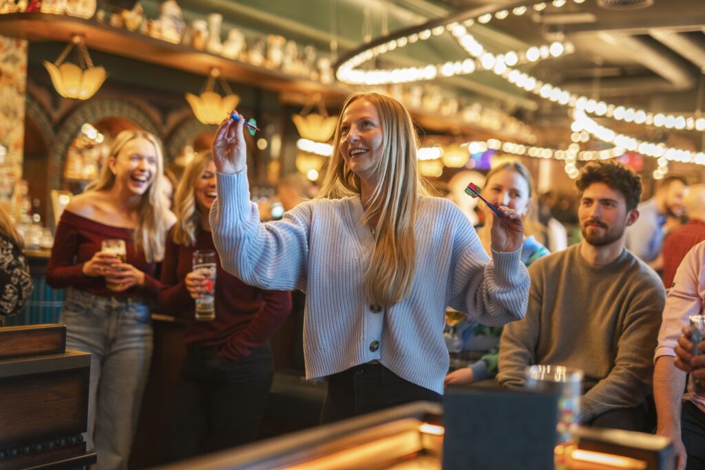 Lady playing Darts with her friend at Flight Club
