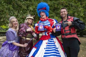 a group of actors in front of trees in colourful outfits