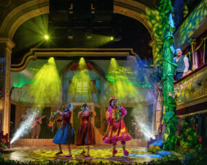 a group of performers on a colourful stage playing saxaphones