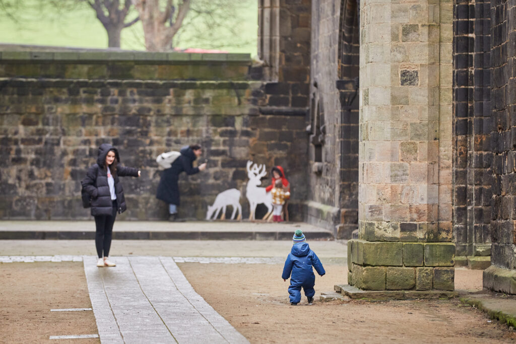 A small child playing inside Kirkstall Abbey