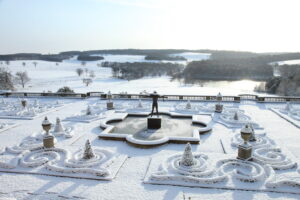 A view looking out over the snow covered terrace and grounds of Harewood House.