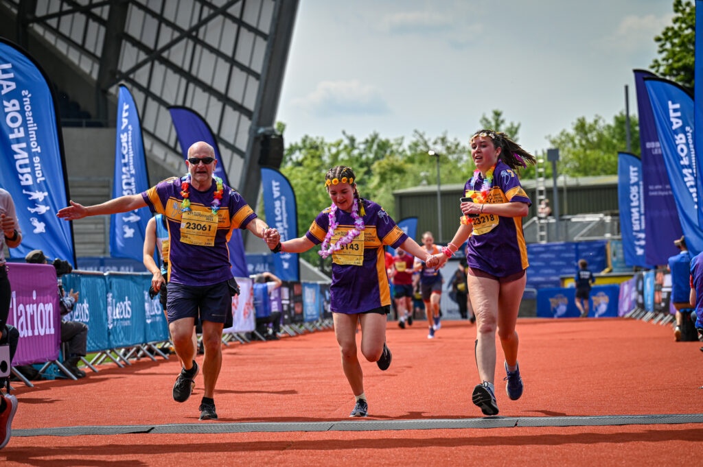 a family holding hands at the finish line of a race