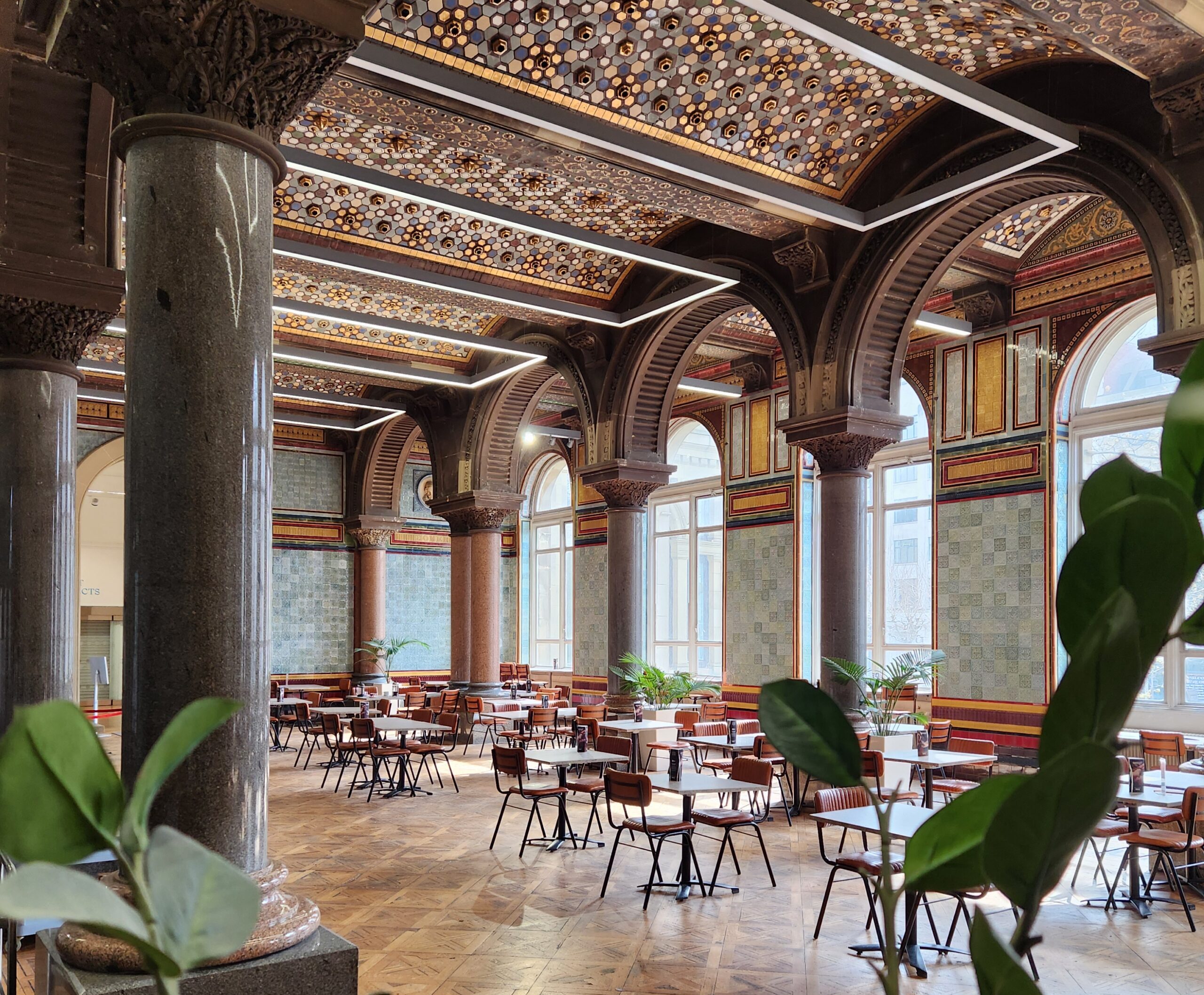 a cafe space inside a tiled room with arches