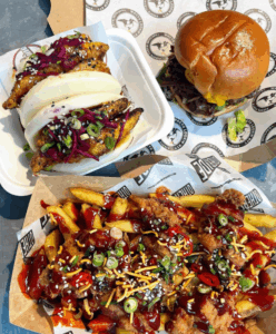 several dishes of food, a burger, loaded fries and bao buns