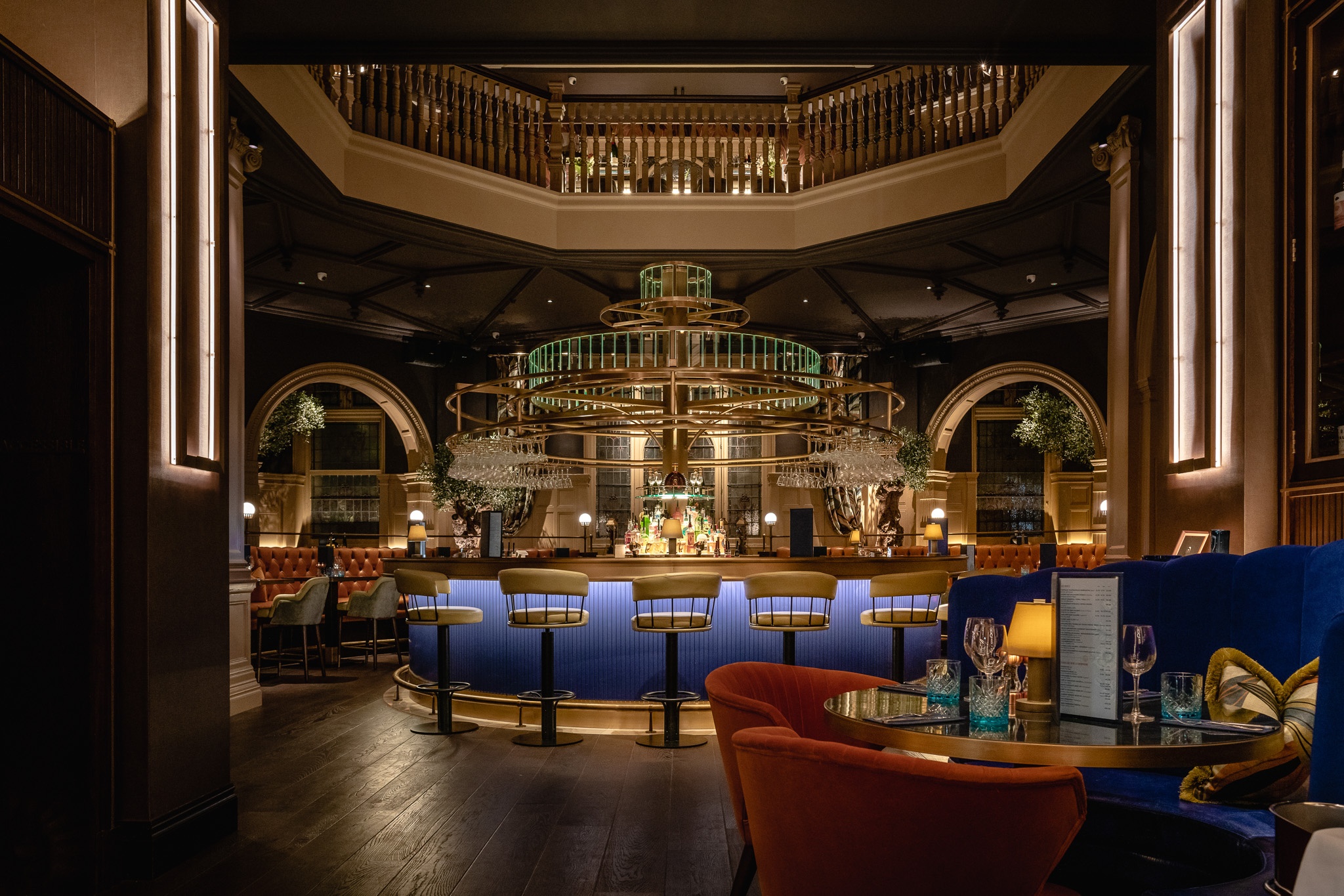 a circular bar space in blue with seats and tables around