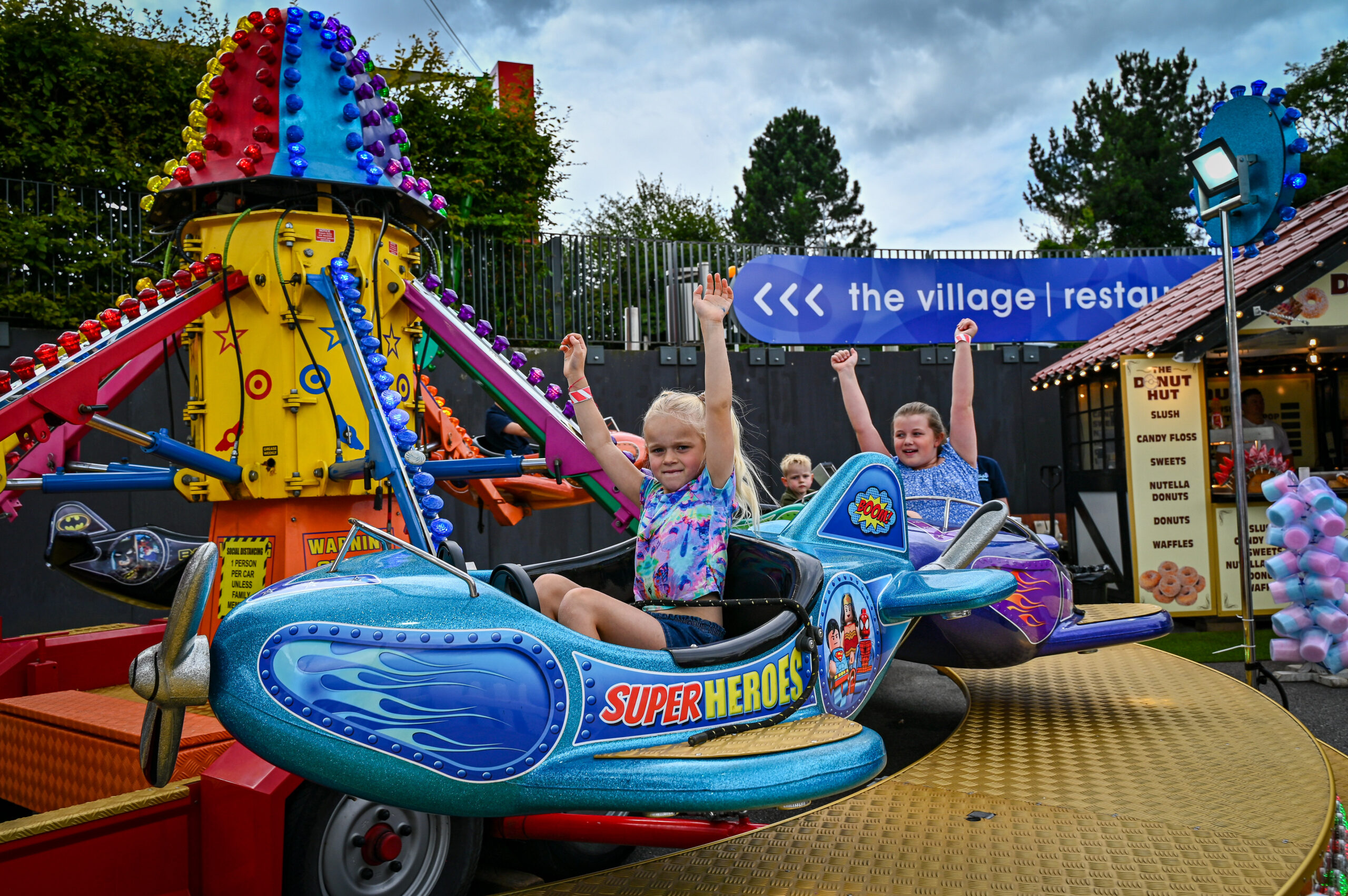 children playing on a carnival ride shaped like rocket ships