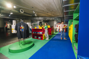 a retail shop filled with lego merchandise including tshirts with people shopping