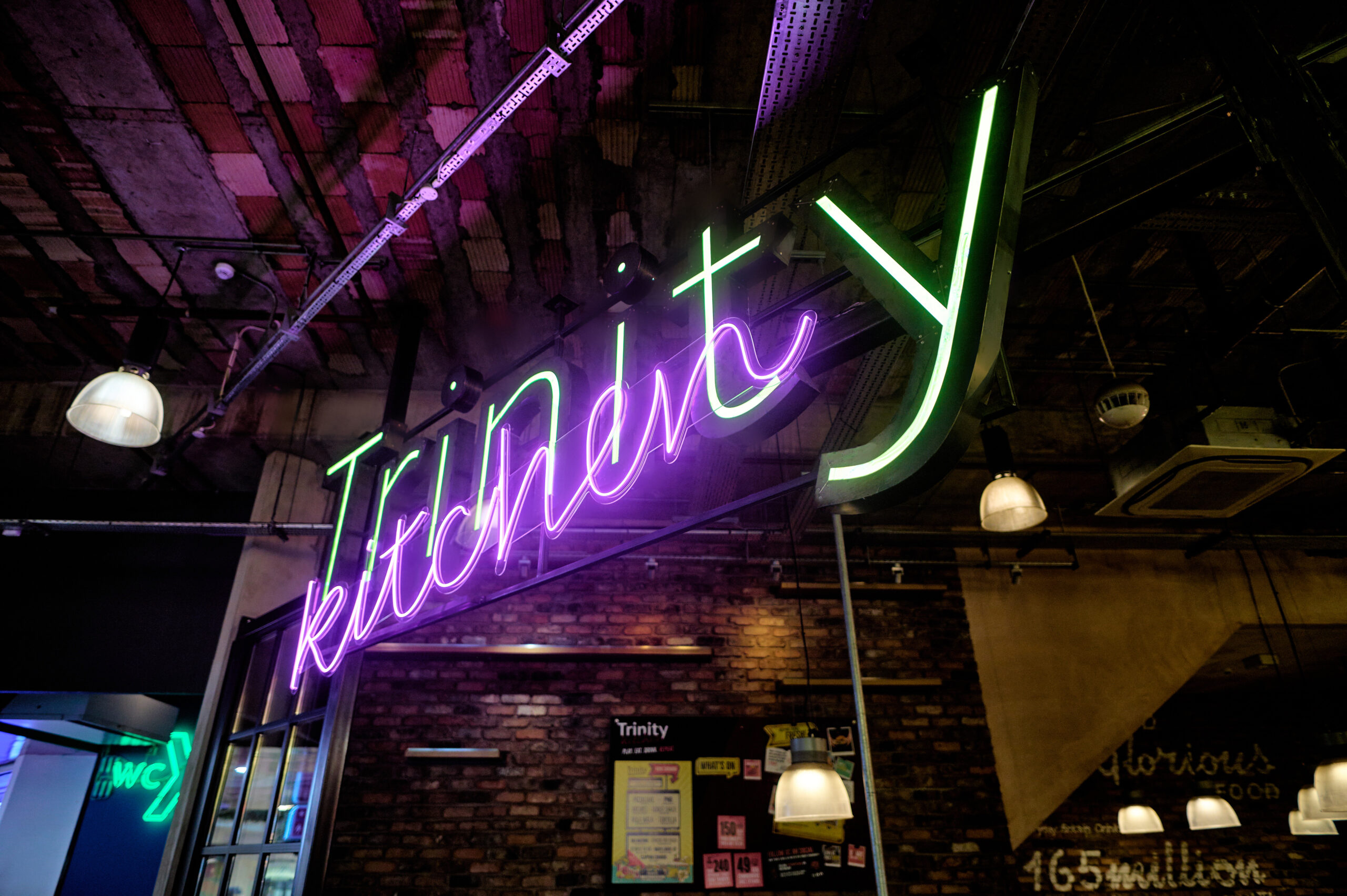 neon sign saying trinity kitchen