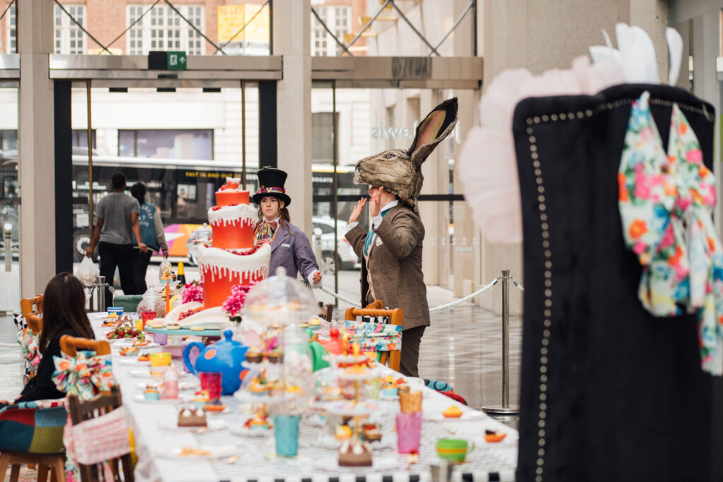 long dining table with many cakes, teapots and teacups on it