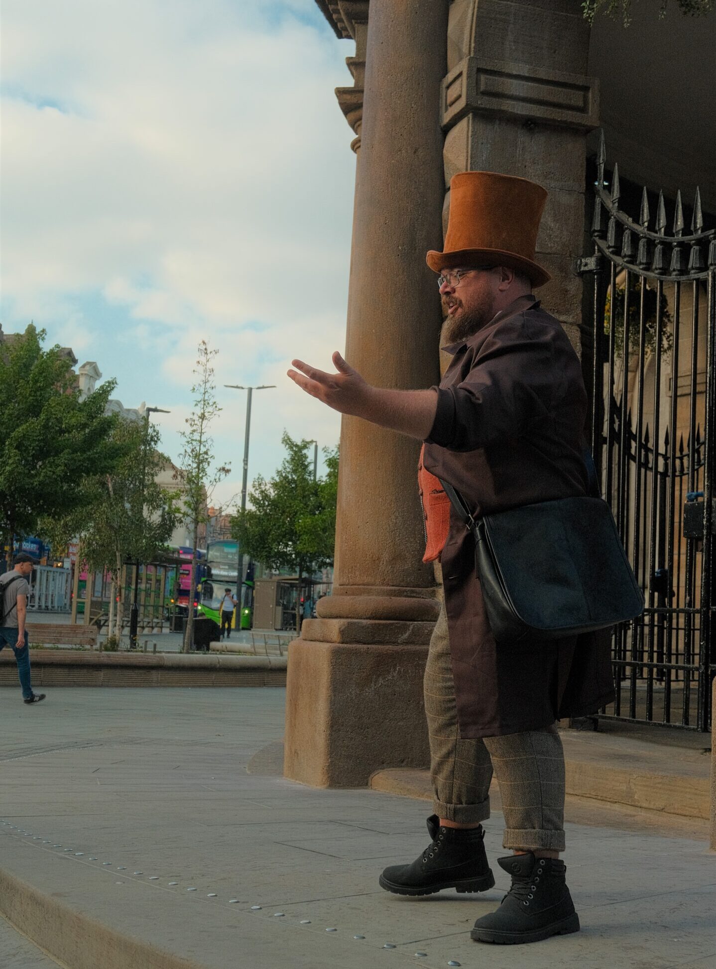 a man dress in top hat and an old style victorian suit in front of an old building