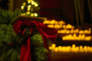 a venue decorated with lit candles, red bows and green wreaths