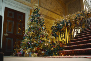 a decorated christmas tree at the bottom of a staircase