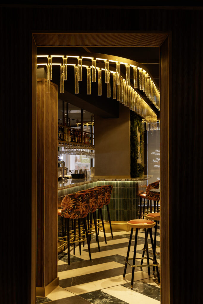 the interior of a restauranrt with low lighting, chairs upto a bar