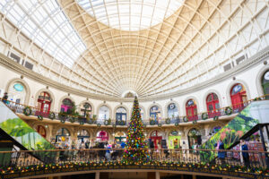 a large indoor shopping centre decorated with a christmas tree and wreaths
