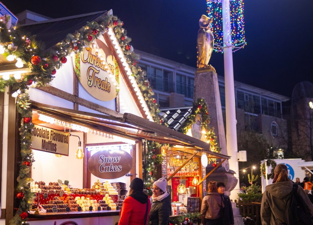 Two women browsing a Christmas Market Stall