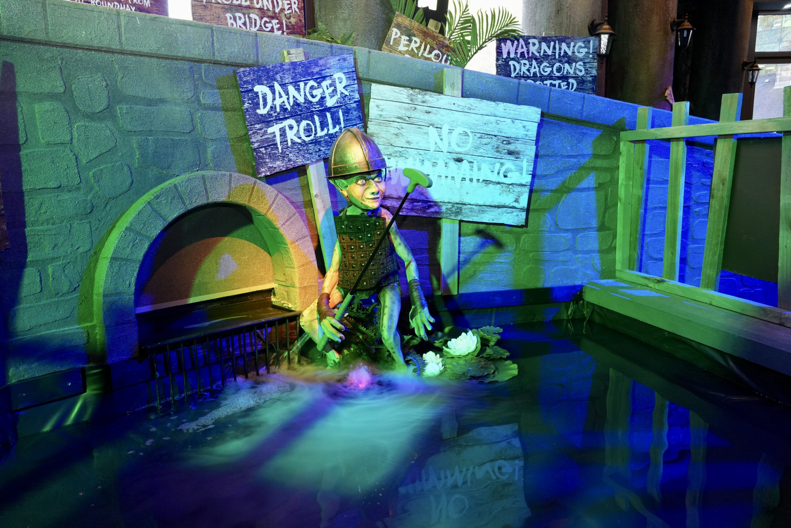 a troll creature under a bridge with signs warning