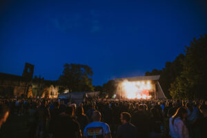 an outdoor concert at nighttime in the ruins of an old abbey