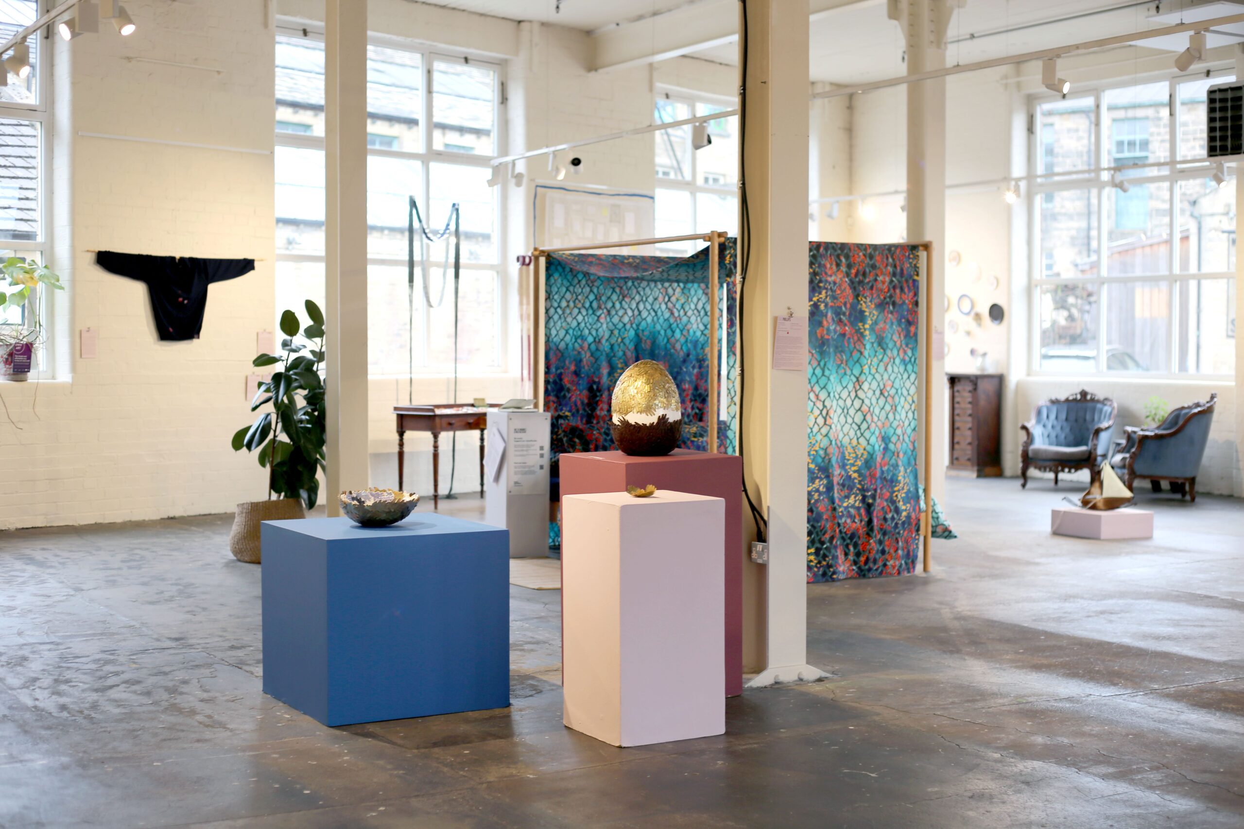an exhibition space filled with objects on podiums