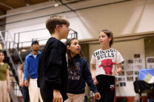 three children practising acting in a blank room