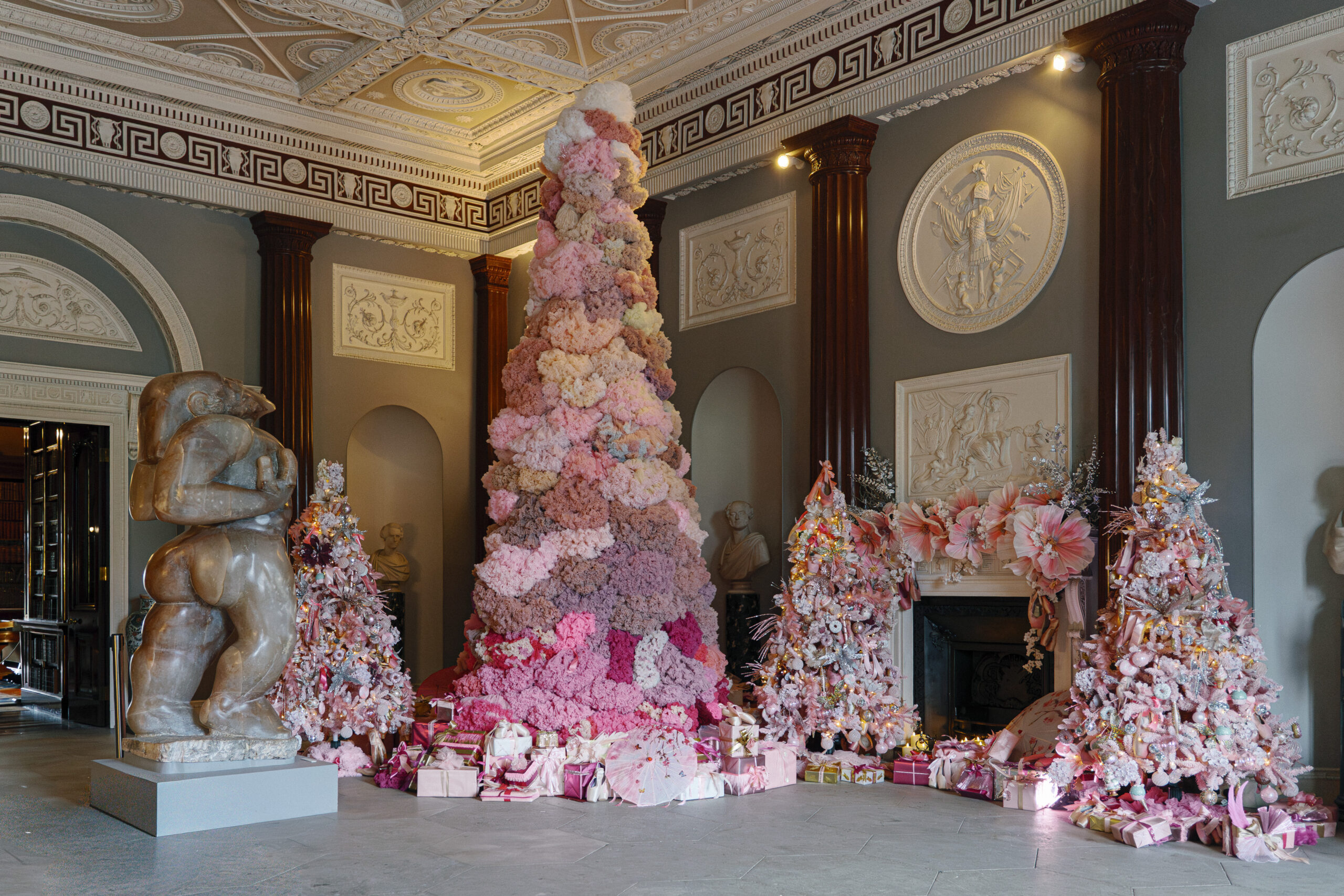 several decorated pink christmas trees in a large room