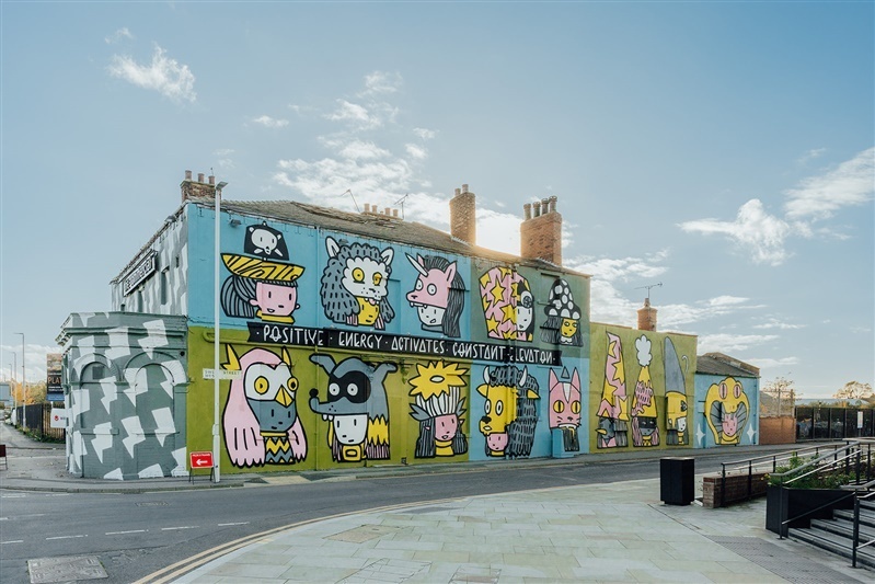 a large building with colourful cartoon characters spray painted on the side