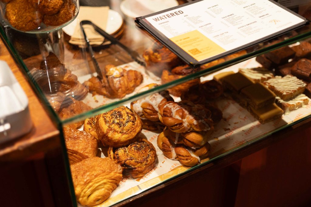 a glass counter in a cafe with pastries inside
