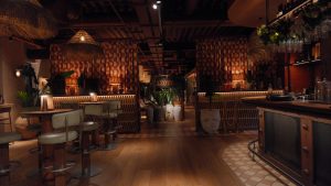 a warmly lit restaurant space, with a bar and bar stools and further back a few tall terracotta and white vases with a sign above saying Azotea