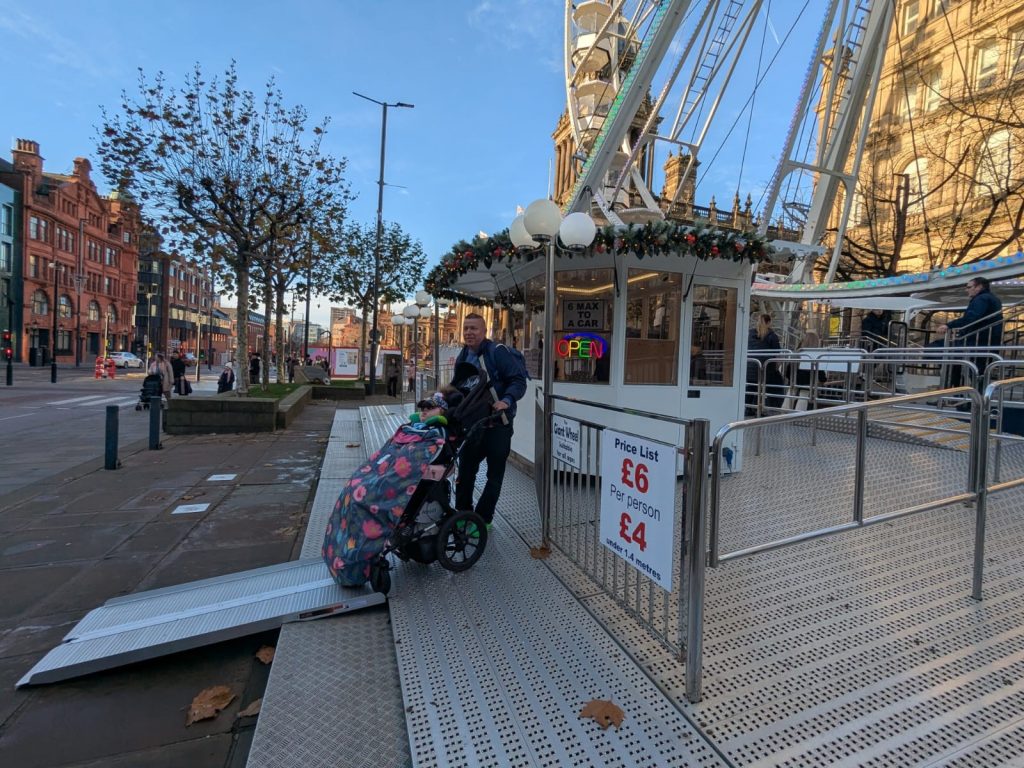 someone in a wheelchair in front of a ferris wheel