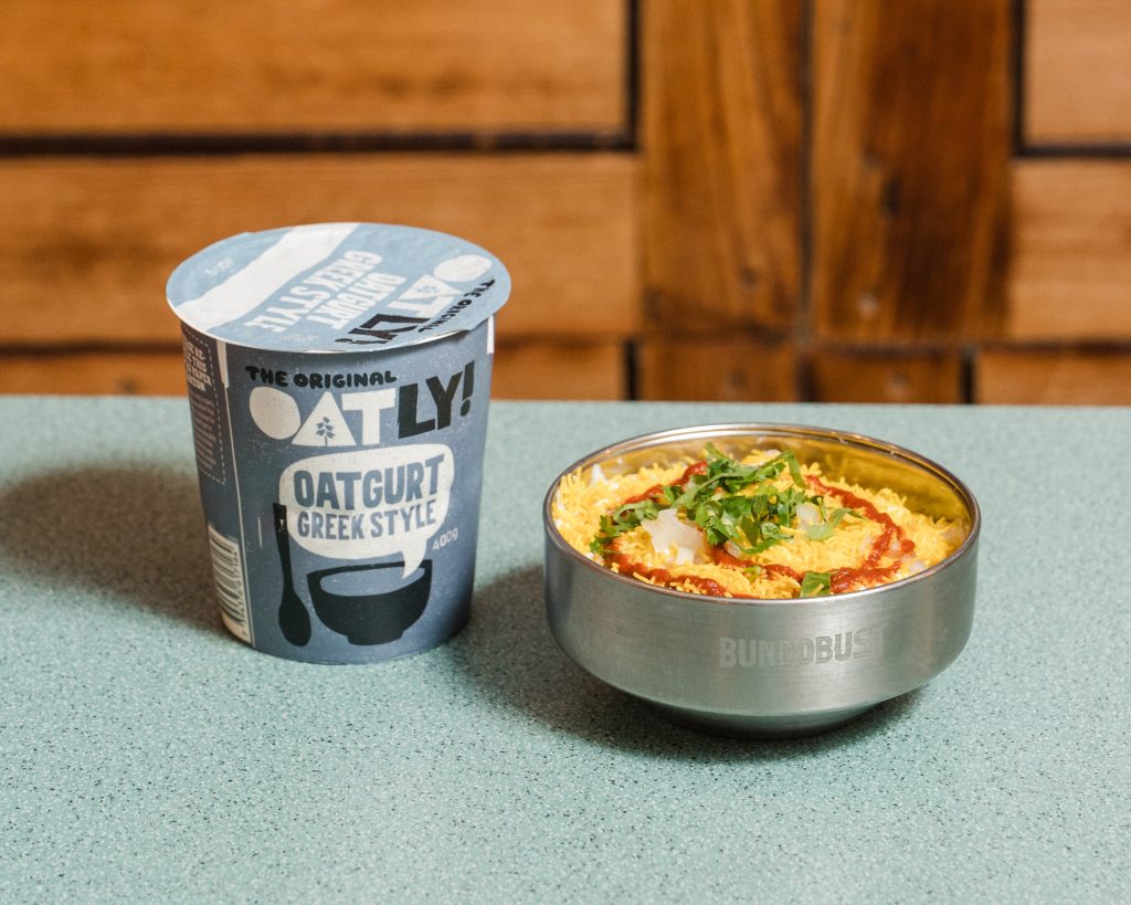 a bowl of food and an oatly oatgurt on a table