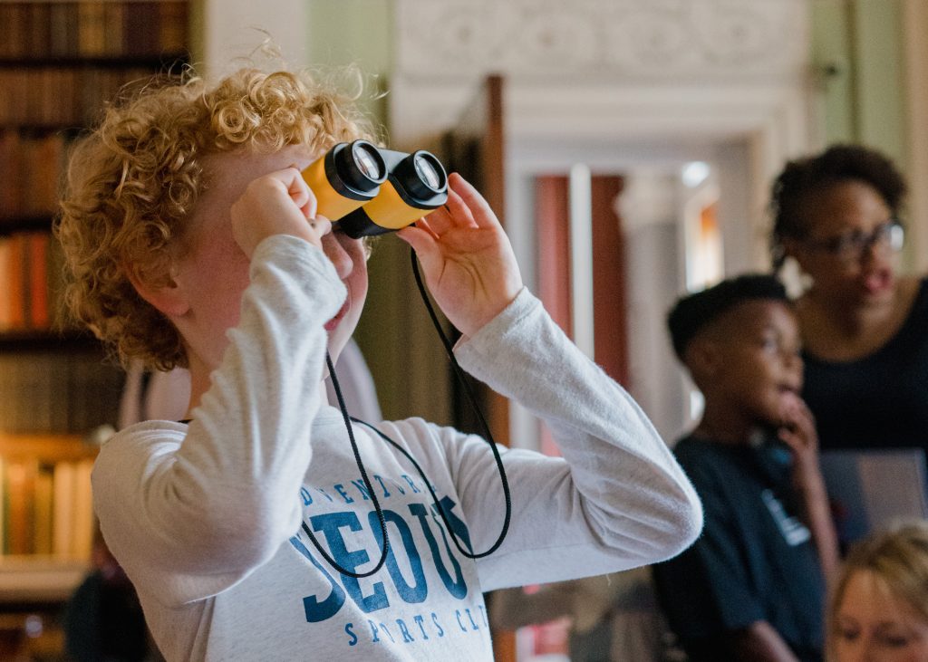 a child holding a pair of binoculars inside a decorated room