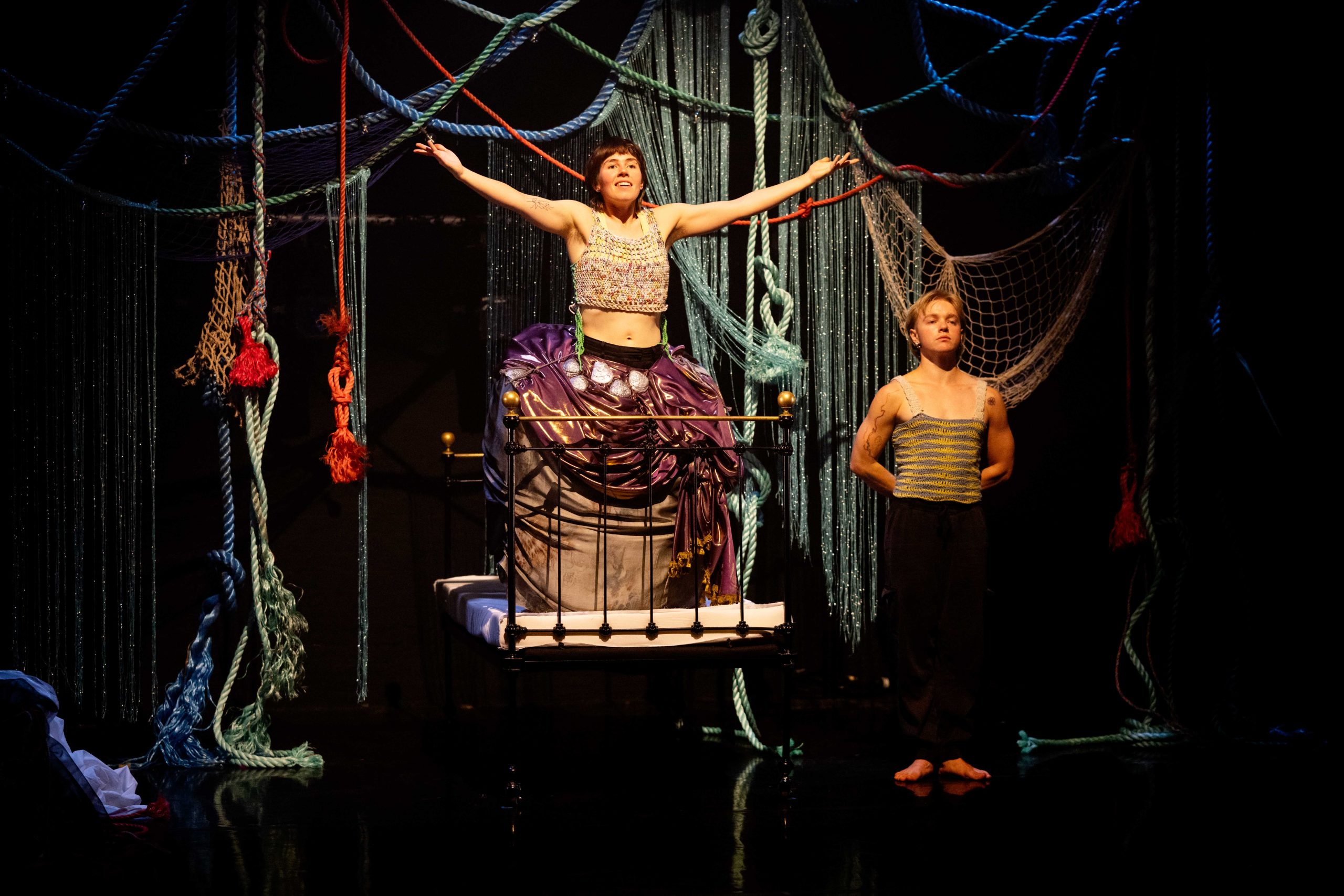 a theatre stage with two people, one in a mermaid tail