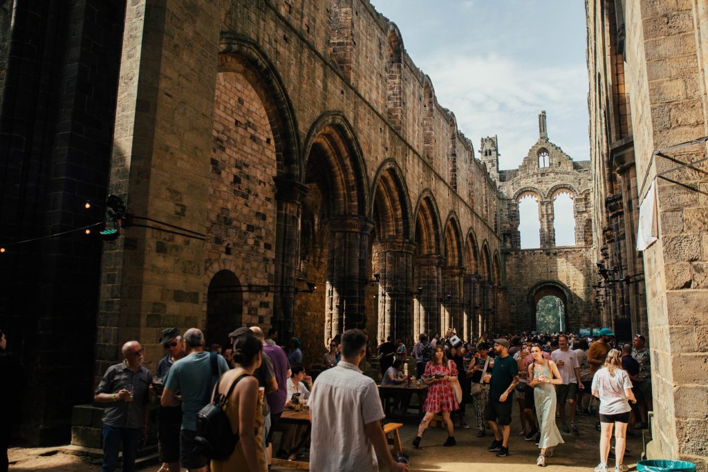 Crown of people within ruins of Kirkstall Abbey in Leeds enjoying the international beer festival